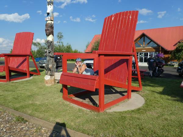 Bright red Adirondack chairs outside the Mackenzie Crossroads Museum in High Level, Alberta